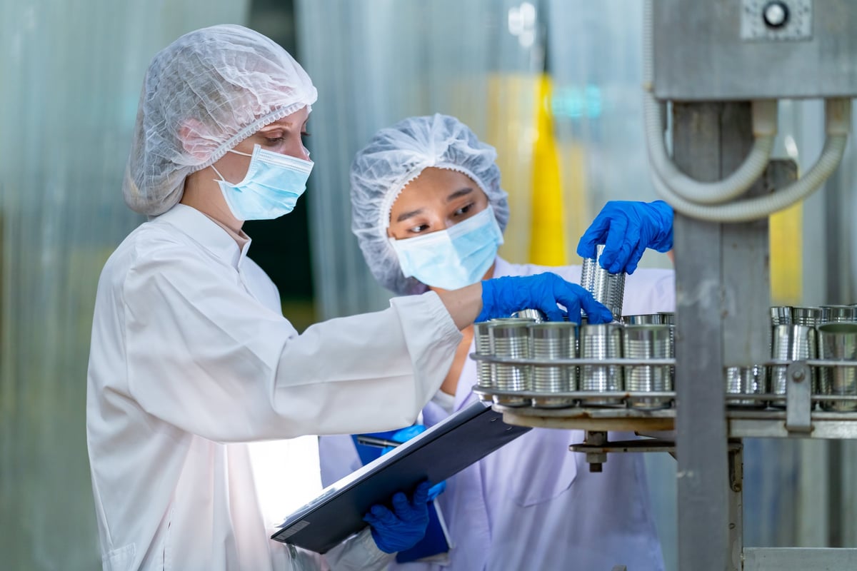 Canned food manufacturing factory industry entrepreneur. Quality control officer inspecting and sampling in production line.