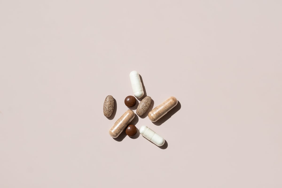 Collection of Various Dietary Supplements and Vitamins Arranged on Light Background. The Capsules are in Different Shapes and Colors.