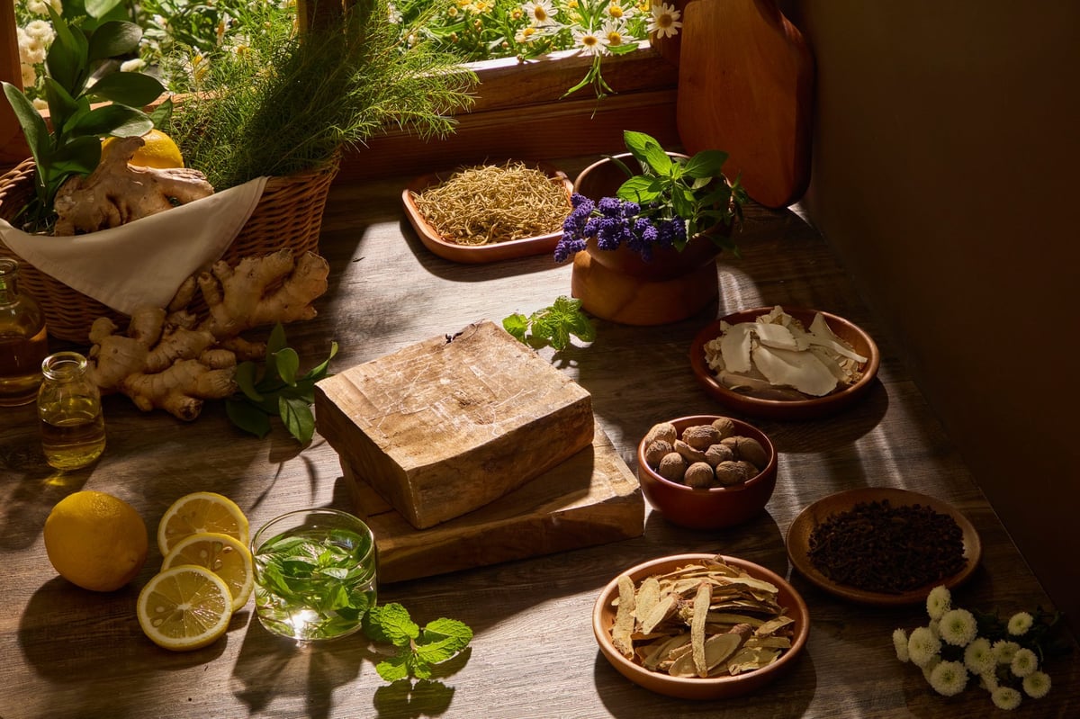 A close composition of herbs, roots, and wooden bowls arranged naturally. Wooden background and sunlight for herbal and eastern medicine branding.
